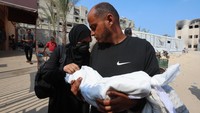 Israa Abu Haleeb dan Ahmed Abu Haleeb, orang tua bayi Palestina Zainab Abu Haleeb yang meninggal akibat malnutrisi, meratapi kepergian putri mereka di Khan Younis, Gaza Selatan, Sabtu (26/7/2025). (REUTERS/Ramadan Abed)  