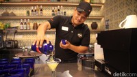 Bartender menyajikan salah satu menu minuman untuk pengunjung.
