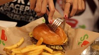 Pengunjung mencoba salah satu menu burger yang disajikan. Sementara Chili’s® Indonesia dikelola oleh Rajafa Boga Group sebagai perusahaan yang telah bergerak di bidang makanan dan minuman (F&B) sejak tahun 2010.