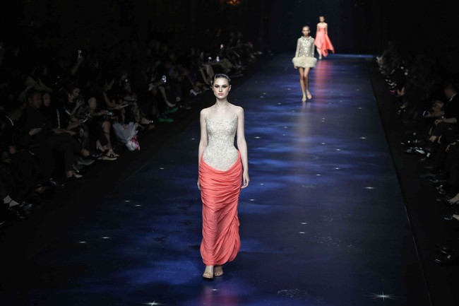 Palet warna dalam koleksi ini mencakup hitam, putih, biru tua, emas, perak, coral, dan kuning, dituangkan ke dalam bahan-bahan seperti jacquard, sifon, crepe, hingga tulle. Siluet arsitektural tampil kokoh dan eksperimental melalui permainan pecah pola, layering, transparansi, serta detail 3D dari draping. (Foto: Pradita Utama/detikcom)