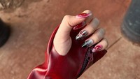 Tiara Andini memperlihatkan detail sarung tangan berwarna merah. Dia juga memakai nail art bernuansa hitam dan merah. Foto: dok. Instagram @tiaraandini