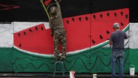 Menurut para aktivis, ini adalah mural yang kedelapan atau kesembilan kalinya, yang terletak di pagar besi yang melindungi monumen Juarez Hemicycle. Foto: REUTERS/Luis Cortes