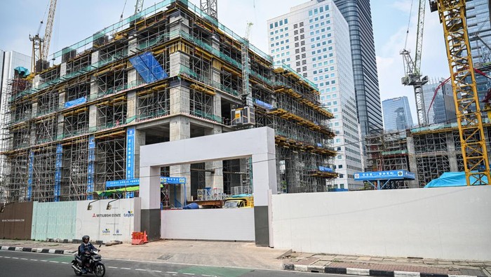 Investasi Tumbuh, Proyek-Proyek Baru Warnai Langit Jakarta Warga melintas di depan proyek pembangunan gedung bertingkat di Jakarta, Selasa (29/7/2025). Menteri Investasi dan Hilirisasi/Kepala Badan Koordinasi Penanaman Modal (BKPM) Rosan Perkasa Roeslani mengungkapkan realisasi investasi pada triwulan II tahun 2025 mencapai Rp477,7 triliun atau meningkat 11,5 persen dari periode sama pada tahun sebelumnya yakni sebesar Rp428,4 triliun. ANTARA FOTO/Fauzan/YU