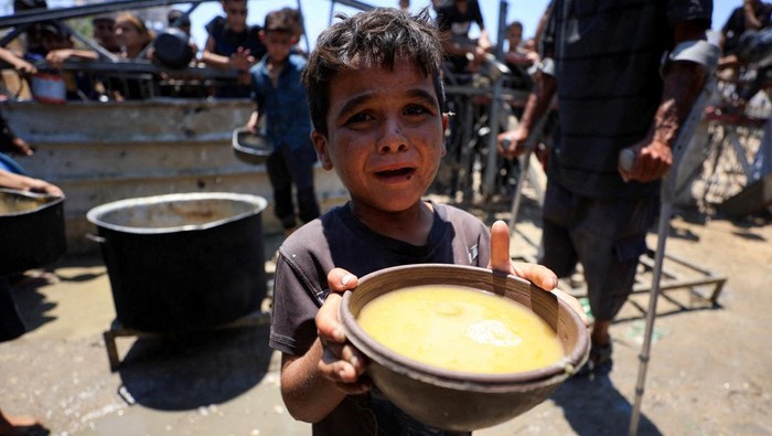A Palestinian child holds a bowl with food received from a charity kitchen, amid a hunger crisis, in Gaza City, July 24, 2025. REUTERS/Dawoud Abu Alkas     TPX IMAGES OF THE DAY