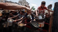 Dengan panci kosong terangkat tinggi dan teriakan kelaparan menggema, mereka berdesakan demi seporsi makanan di tengah krisis pangan yang kian parah. (REUTERS/Khamis Al-Rifi) 