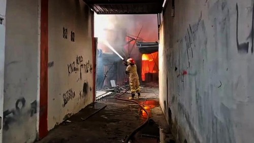 Petugas Damkarmat Lombok Timur sedang berusaha memadamkan kebakaran gudang bengkel di Desa Apitaik Kecamatan Pringgabaya, Lombok Timur, NTB, Senin (28/7/2025). (Humas Polres Lombok Timur)