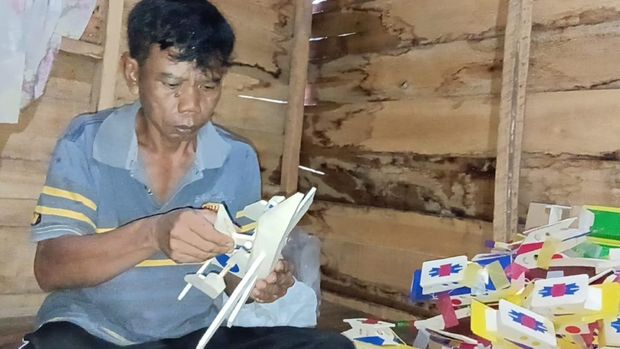 Salim saat membuat miniatur pesawat dan kapal.
