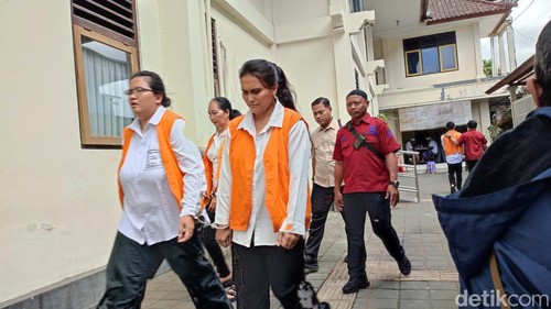 Tiga wanita kasus pembunuhan dan pembuangan mayat pria bertato berjalan di area PN Denpasar untuk bersiap menjalani persidangan, Selasa (29/7/2025).