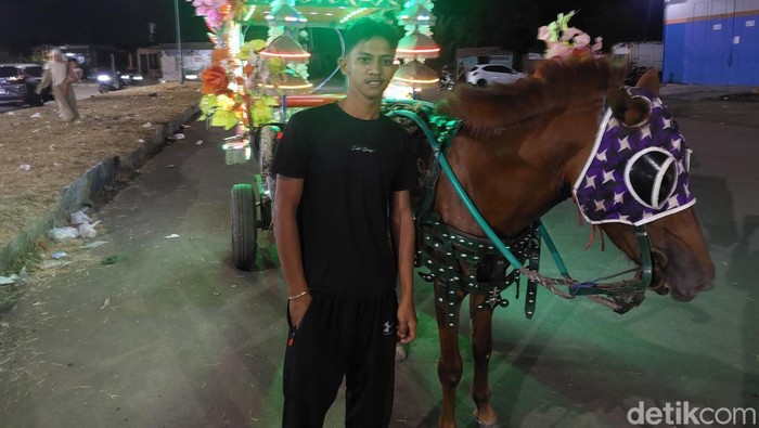 Ardi saat menunjukkan kuda dan delman yang dimilikinya