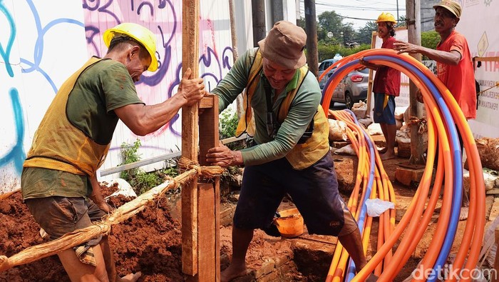 Cegah Semrawut, Proyek Kabel Bawah Tanah Dikebut Para pekerja menyelesaikan proyek penanaman kabel bawah tanah di Jl Ophir, Kebayoran Baru, Jakarta Selatan, Rabu (30/7/2025). Pemerintah Provinsi DKI Jakarta terus menggenjot program penataan kabel udara dengan cara memindahkannya ke dalam tanah.