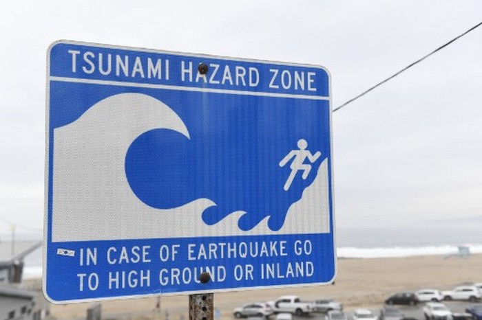 (FILES) A tsunami hazard zone sign is seen near a beach in El Segundo, California, on January 15, 2022. A massive 8.7 earthquake off Russias far east has prompted tsunami warnings of waves up to three meters possibly hitting the coasts of Russia and Hawaii, US authorities warned late on July 29, 2025. Waves one to three meters (3.3 to 10 feet) high could also threaten Japan and the US island territory of Guam, according to the US Pacific Tsunami Warning Center based in Honolulu. (Photo by Patrick T. FALLON / AFP)