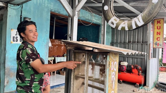 Heru menunjukkan outlet BBM eceran yang kosong di depan bengkel miliknya