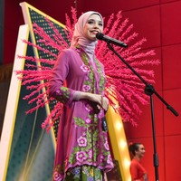 Dalam salah satu foto terlihat Isabel mengenakan kebaya ungu dengan bordir bunga-bunga cerah. Ornamen merah mencolok di latar belakang menambah kesan megah penampilannya. Ia tampak tenang dan anggun menjawab pertanyaan dewan juri. Foto: Instagram/@isabel.azhari