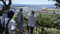 Warga mengamati garis pantai dari Taman Hiyoriyama, Ishinomaki, Prefektur Miyagi, Jepang, Selasa (30/7/2025). Pemerintah Jepang mengeluarkan peringatan tsunami usai gempa besar mengguncang Kamchatka, Rusia. (Kyodo/via REUTERS) 