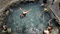Anak-anak lelaki berkumpul untuk menyejukkan diri di kolam renang selama gelombang panas di kota Diyarbakir, Turki bagian tenggara. Suhu tertinggi yang pernah tercatat di Turki tercatat pada hari Jumat (25/7) di tengah gelombang panas yang menyesakkan di seluruh negeri yang telah memicu puluhan kebakaran hutan dan membuat warga mencari cara untuk menghindari panas. Foto: REUTERS/Sertac Kayar