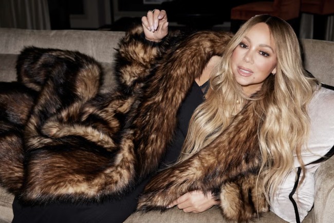 Sambil duduk anggun di sofa, Mariah memperlihatkan gaya mewahnya. Pelantun All I Want For Christmas is You itu mengenakan coat bulu yang semakin menegaskan gaya glamornya. Foto: dok. Harpers Bazaar UK