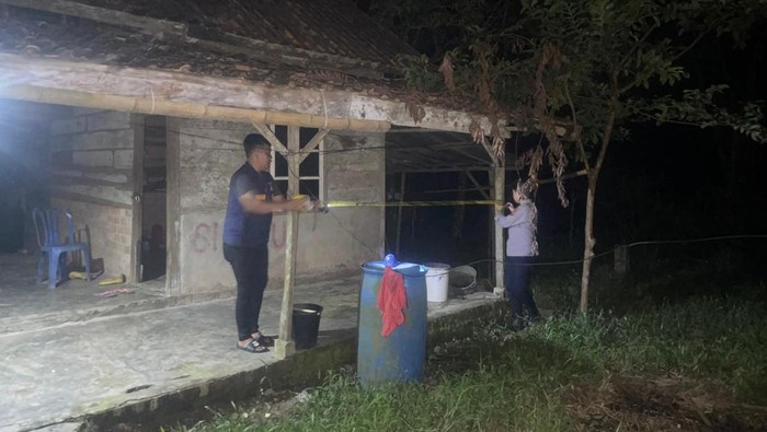 Polisi memasang garis polisi di tempat wanita lansia dibunuh rekannya