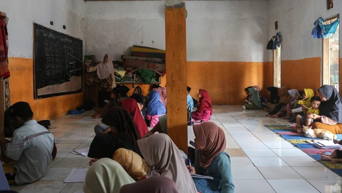 Semangat Belajar Siswa Madrasah di Pandeglang Meski Fasilitas Terbatas Sejumlah siswa mengikuti kegiatan belajar mengajar tanpa meja dan kursi di Madrasah Diniyah Takmiliyah Awaliyah (MDTA) Hidayatul Mubtadiβin, Pulosari, Kabupaten Pandeglang, Banten, Rabu (30/7/2025). Menurut pihak madrasah yang berlokasi di kaki Gunung Pulosari dan didirikan tahun 2007 serta memiliki murid sebanyak 70 orang itu belum bisa melengkapi fasilitas meja dan kursi untuk siswa karena kekurangan anggaran, sementara tenaga pengajarnya dibayar secara sukarela oleh orang tua murid dan hanya mendapatkan dana hibah rata-rata Rp5 juta per tahun. ANTARA FOTO/Angga Budhiyanto/tom.