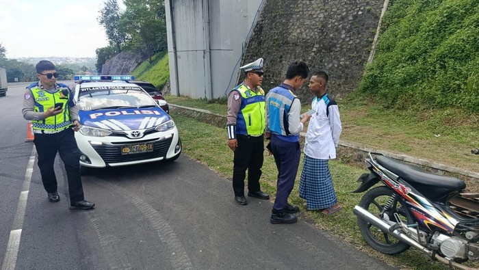 Momen pemotor yang mengenakan sarung saat dihentikan polisi karena berkendara di Tol Semarang-Solo, Rabu (30/7/2025) siang.