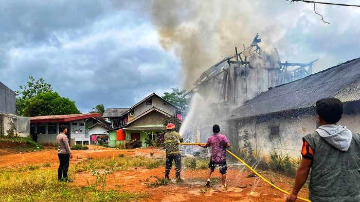 Warga bersama petugas berupaya memadamkan api yang melahap asrama putra Pesantren Al-Kahfi di Jampangkulon, Kamis (31/7/2025). Bangunan berbahan kayu itu hangus dalam waktu singkat
