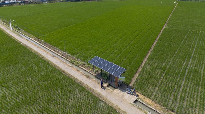 Foto udara petani setempat melakukan perawatan instalasi pembangkit listrik tenaga surya (PLTS) untuk mesin pompa air irigasi di persawahan desa Juntinyuat, Indramayu, Jawa Barat, Kamis (31/7/2025). Petani memanfaatkan Pembangkit Listrik Tenaga Surya (PLTS) dengan total daya sebesar 7,7 Kilowatt (kWp) bantuan dari Pertamina Gas OWJA sebagai sumber energi untuk menyalakan mesin pompa air irigasi yang mengairi 30 hektar lahan sawah tadah hujan di wilayah itu. ANTARA FOTO/Dedhez Anggara/bar