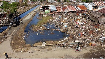 Puing-puing tsunami terlihat di Meulaboh, sebuah kota di Provinsi Aceh, Indonesia, 31 Desember 2004. Bawah: Area yang sama terlihat pada 4 Desember 2005. Foto: Radio Free Asia