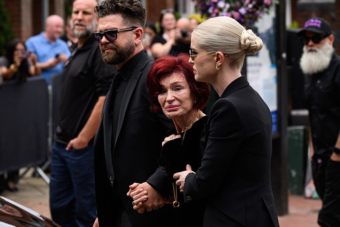 BIRMINGHAM, ENGLAND - JULY 30: (L-R) Jack Osbourne, Sharon Osbourne and Kelly Osbourne leave after viewing tributes to the late Ozzy Osbourne from fans as his funeral cortege travels through his home city of Birmingham on July 30, 2025 in Birmingham, England. The Black Sabbath frontman passed away on July 22nd at the age of 76. His death occurred just a little over two weeks after his final live performance at the Back to the Beginning concert in his hometown of Birmingham. (Photo by Leon Neal/Getty Images)