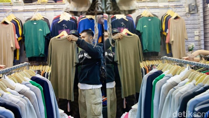 Sejumlah warga memilih berbelanja pakaian thrifting di kaswasan Jakarta Pusat, Kamis (31/7/2025). Bisnis thrifting barang impor ilegal di Tanah Air masih menjamur. Kemenperin menyebut kerugian produsen lokal akibat thrifting bisa mencapai triliunan rupiah.