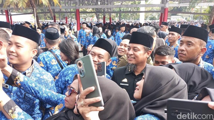 Gubernur Sulsel Andi Sudirman Sulaiman melayani permintaan foto bersama PPPK yang baru menerima SK pengangkatan.