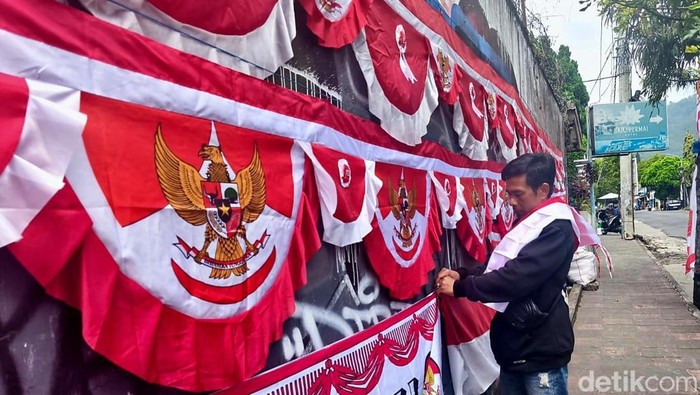 Topan sedang menata bendera yang akan dijual