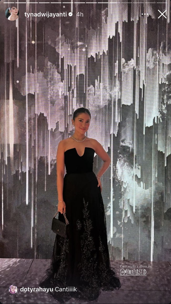 Sama seperti kebanyakan para tamu undangan lain, Tyna Dwijayanti juga memilih gaun hitam strapless yang elegan. Bagian bawah gaun panjangnya itu memiliki detail seperti motif floral yang berkilauan. Foto: Instagram