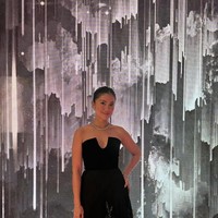 Sama seperti kebanyakan para tamu undangan lain, Tyna Dwijayanti juga memilih gaun hitam strapless yang elegan. Bagian bawah gaun panjangnya itu memiliki detail seperti motif floral yang berkilauan. Foto: Instagram