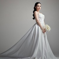 Steffi Zamora tampil anggun dalam balutan gaun pengantin putih satin yang memadukan gaya klasik dan modern minimalis. Gaun strapless dengan detail drapery di bagian dada dan potongan korset memberikan siluet feminin sekaligus tegas. Foto: Instagram/@steffizamoraaa