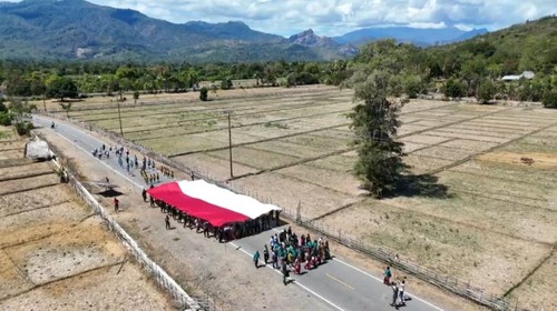Bendera Merah Putih raksasa diarak di sepanjang jalan Amfoang Timur, Kabupaten Kupang, NTT, Jumat (1/8/2025).