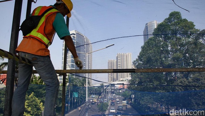 Petugas mengelupas cat pada rangka besi saat pemeliharaan Jembatan Penyeberangan Orang (JPO) Margaguna Raya, di kawasan Pondok Indah, Jakarta Selatan, Jumat (1/8/2025). Revitalisasi JPO tersebut ditargetkan rampung pada November 2025 guna menjaga keamanan dan kenyamanan bagi warga pengguna JPO tersebut.