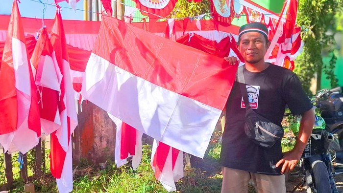 Leo dan sejumlah bendera dagangannya. Foto: Oktavian Balang/detikKalimantan