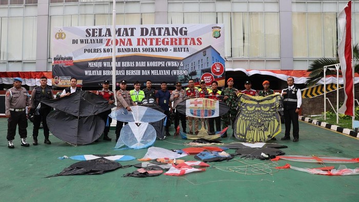 Petugas menertibkan puluhan layangan yang diterbangkan di Bandara Soekarno-Hatta, Jumat (8/1/2025).
