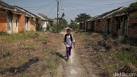 Seorang anak melintas di kawasan Perumahan Villa Kencana Cikarang. Perumahan ini dulu sempat diresmikan Presiden Jokowi pada tahun 2017. Tetapi kini banyak ditinggalkan warganya.Di atas tanah yang dulu digadang-gadang sebagai “harapan baru” bagi rakyat kecil, kini hanya tersisa deretan rumah-rumah sunyi yang ditinggalkan. Perumahan subsidi Green New Residence Babelan dan Villa Kencana Cikarang yang dulunya dipasarkan sebagai solusi untuk rakyat berpenghasilan rendah, kini justru menjadi Kuburan bagi mimpi mimpi yang tak pernah sempat tumbuh.