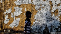 Siluet anak yang melintas di depan tembok perumahan subsidi yang hancur. Di dalam setiap retakan tembok itu, terselip kisah orang-orang kecil yang pernah berharap. Di balik pintu-pintu yang tertutup rapat, ada keluarga yang kini lebih memilih diam daripada bicara tentang kecewa. Mereka tak butuh rumah mewah. Mereka hanya ingin rumah yang layak. Tapi  itu pun tak mereka dapatkan.