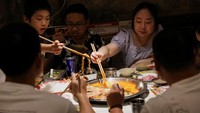 Pengunjung menikmati hidangan hotpot. Suhu di dalam restoran tetap 25 derajat Celcius (77 derajat Fahrenheit) sepanjang tahun, sementara suhu di luar mencapai puncaknya di 40 derajat Celcius (104 derajat Fahrenheit) pada hari Kamis. Foto: REUTERS/Go Nakamura