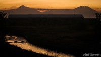 Senja di musim kemarau menghadirkan cahaya hangat yang menyorot lekuk gunung dengan jelas. Merapi tampak tegas di sisi selatan, sementara Merbabu terlihat lebih landai di utara. Waktu terbaik untuk menikmati pemandangan ini biasanya sekitar pukul 17.00 hingga matahari terbenam. 