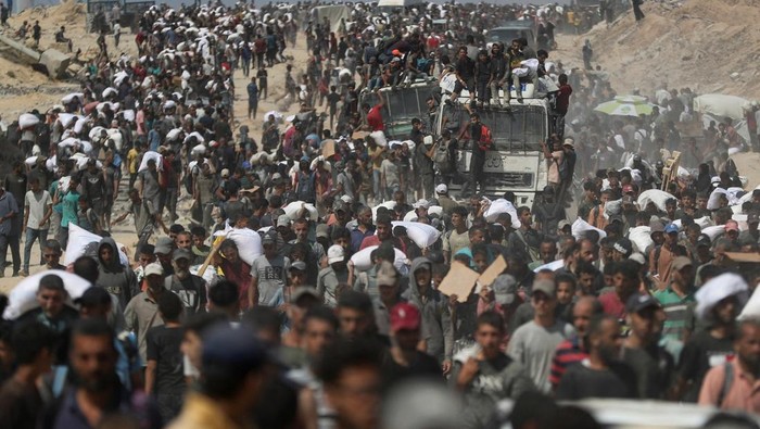 βHujanβ Bantuan Kemanusiaan di Langit Gaza Palestinians carry aid supplies that entered Gaza through Israel, in Beit Lahia, northern Gaza Strip, August 1, 2025. REUTERS/Mahmoud Issa