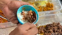 Begini cara membuat nasi cokot. Nasi putih dimasukkan ke cetakan nasi, kemudian bagian tengahnya diisi lauk oseng cumi. Baru terakhir ditutup dengan nasi putih. Foto: Yenny Mustika Sari/detikcom