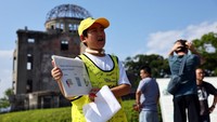 Dengan senyum dan semangat, Shun mengenakan bib khas saat memandu tur dua mingguan di taman peringatan, menarik perhatian wisatawan dari berbagai negara. Foto: REUTERS/Issei Kato