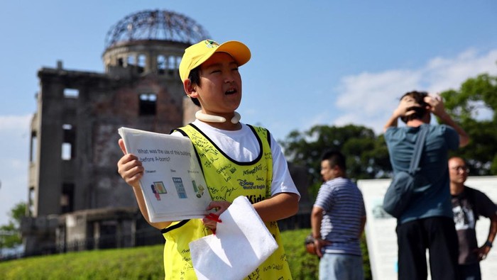 Shun Sasaki, 12, an elementary school student in Hiroshima, guides foreign visitors in English as a volunteer guide in front of the Atomic Bomb Dome in Hiroshima, western Japan July 15, 2025.   REUTERS/Issei Kato     TPX IMAGES OF THE DAY