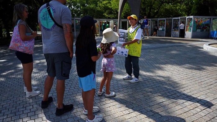 Potret Siswa 12 Tahun Pandu Tur Perdamaian di Hiroshima Shun Sasaki, 12, an elementary school student in Hiroshima, guides foreign visitors in English as a volunteer guide in front of the Atomic Bomb Dome in Hiroshima, western Japan July 15, 2025. REUTERS/Issei Kato TPX IMAGES OF THE DAY