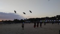 Peserta unjuk kebolehan menerbangkan layang-layang di Rare Angon Festival 2025 di Pantai Mertasari, Jumat (1/8/2025) sore. Layang-layang itu membentuk pola-pola tertentu saat menari di langit.