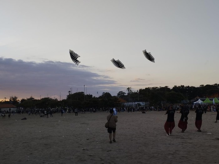 Peserta unjuk kebolehan menerbangkan layang-layang di Rare Angon Festival 2025 di Pantai Mertasari, Jumat (1/8/2025). Layang-layang itu membentuk pola-pola tertentu saat menari di langit.