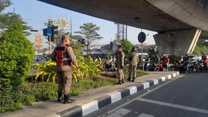 Sejumlah petugas Satpol PP Surabaya melakukan pengawasan anak-anak yang bermain layangan dan berpotensi membahayakan pengguna jalan.