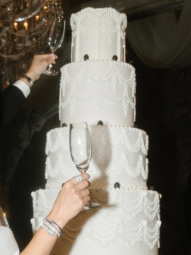 Serba putih dengan hiasan anggur hitam di pinggirannya, cake ini selaras dengan tema pesta The Sun and Moon yang serba hitam-putih. Foto: Instagram/@caliaphoto @lenovellecake